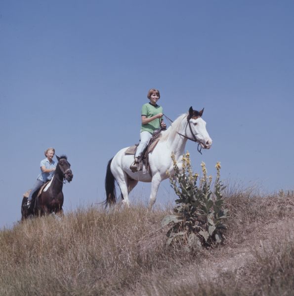 Two women riding horses on the top of a hill in Kettle Moraine State Forest.