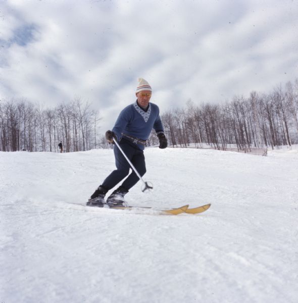 A man is skiing down a snow-covered hill at Mt. Ashwabay Ski and Recreation Area.