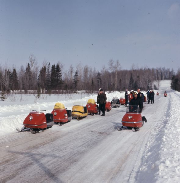 A group of snowmobilers standing and resting on a plowed path in Nicolet National Forest.