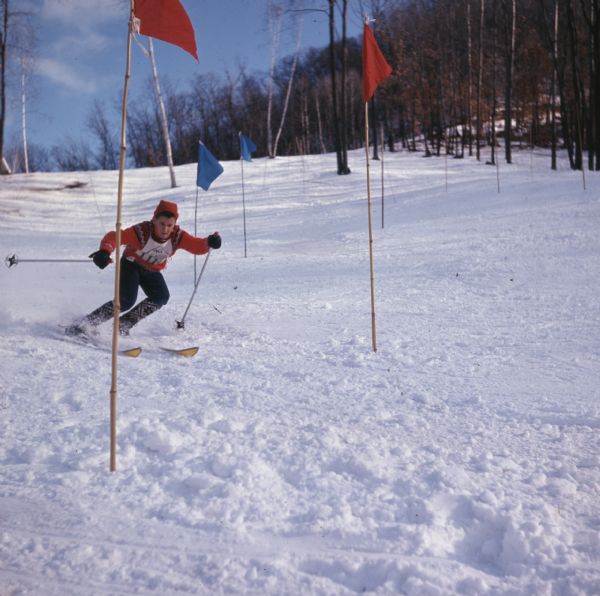 A man is skiing down a slope around slalom flags.