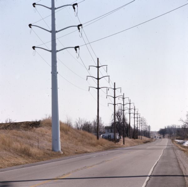 View of power lines and utility poles along a road. 