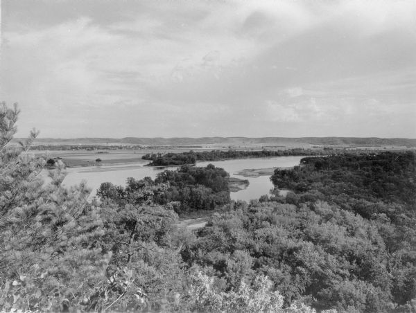 Elevated panoramic view of the Wisconsin River looking north from Tower Hill State Park. There are sandbars in the river. The water tower and village of Spring Green are on the left in the distance.