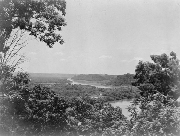 Elevated view, looking north, from Mt. Hosmer, with tall bluffs on the far (Wisconsin) side of the Mississippi River. There are multiple sloughs and islands in the river valley.