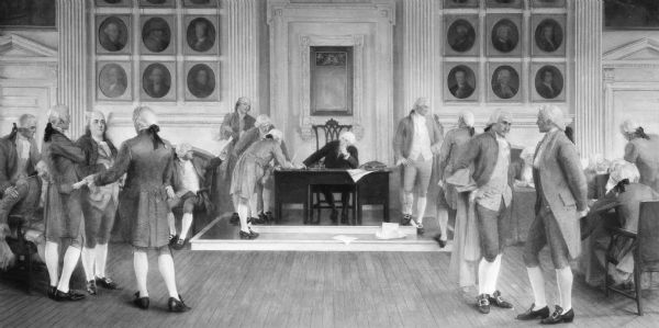 Painting, in the Wisconsin State Capitol, of "The Signing of the American Constitution," one of four mural paintings by Albert Herter on the west wall of the Supreme Court. The scene represents American law, and depicts the signing of the Constitution of the United States of America in 1787 in Philadelphia, Pennsylvania, with George Washington presiding over the occasion. Washington is in the chair behind the table on a low dais. On the right in the foreground are James Madison, with a cloak on his arm, and Alexander Hamilton, standing. Farther back near Washington Thomas Jefferson is talking to another delegate whose back is turned. In the group of four men standing on the left in the foreground is Benjamin Franklin.