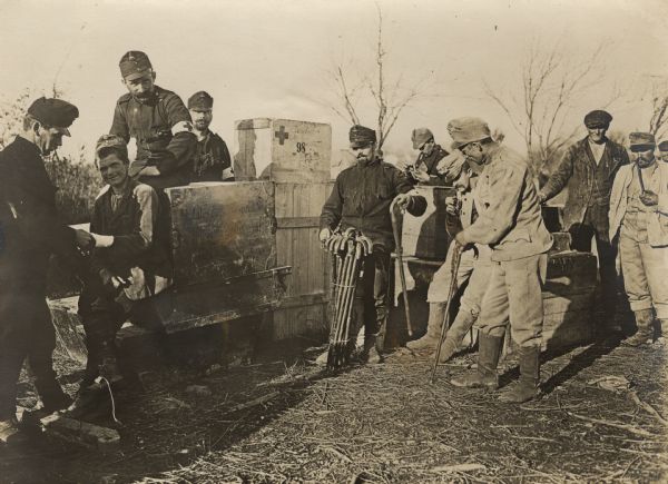 A traveling field hospital assisting soldiers on the battlefield. One man in the center is handing out canes.