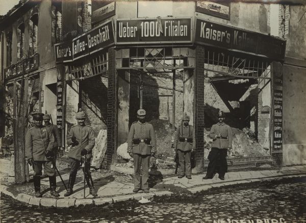 German soldiers posing in front of a destroyed storefront in the city of Neidenburg in East Prussia in September 1914.  Taken after the expulsion of Russian forces which had invaded East Prussia in August 1914 and been subsequently defeated at the Battle of Tannenberg.