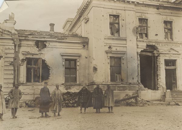 Soldiers and officers are posing in front of the destroyed Customs House in Sabac, Serbia.