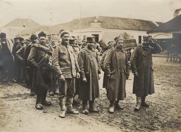 A group of Serbian prisoners standing on a street.