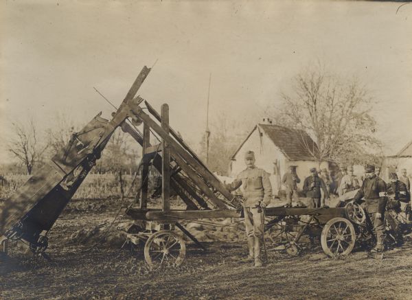 Austrian soldier posing in front of a piece of harvesting equipment destroyed by shelling in Sabac, Serbia.