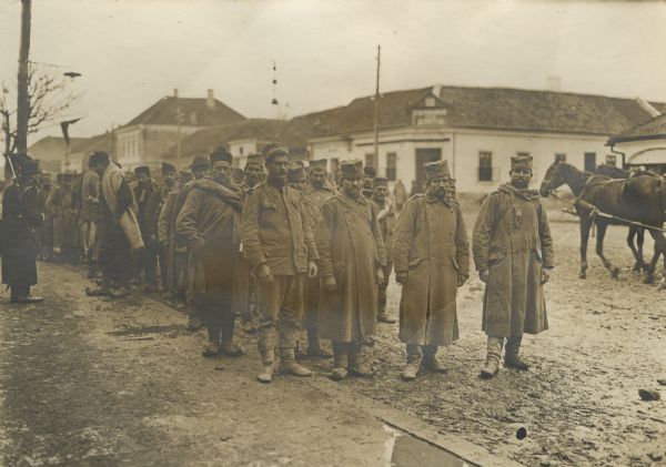 A group of Serbian prisoners standing on a street. 