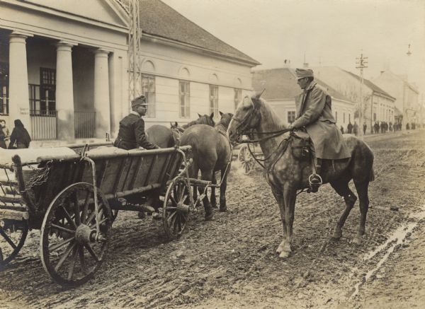 An Austrian cavalry soldier asking a wagon driver for information and directions.
