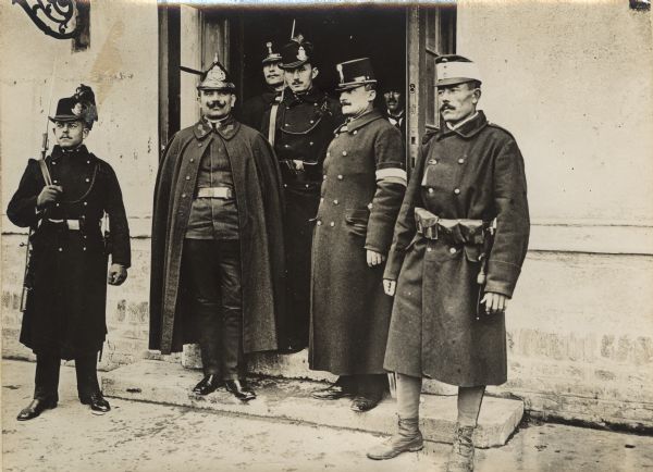 Austrian gendarmes and other officials standing outside a train depot  entrance in Serbia during World War I. 