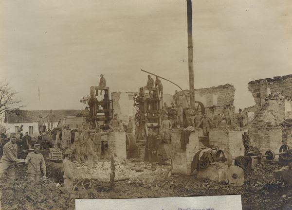 Austrian soldiers clearing the rubble of a large factory in order to use bricks and stones for the repair of bad roadways.