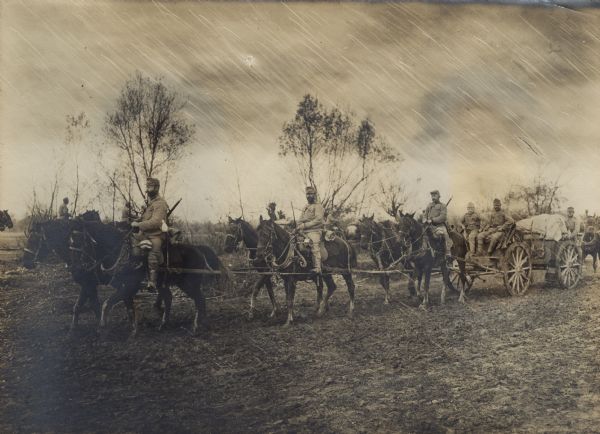 Austrian supply column of soldiers on horseback and on wagons trudging through the rain and mud in Serbia during World War I. 