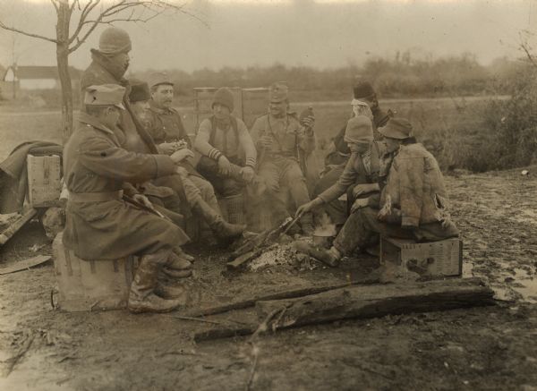 Slovenian and Croatian civilians and Austrian soldiers are sitting around a campfire during World War I. 