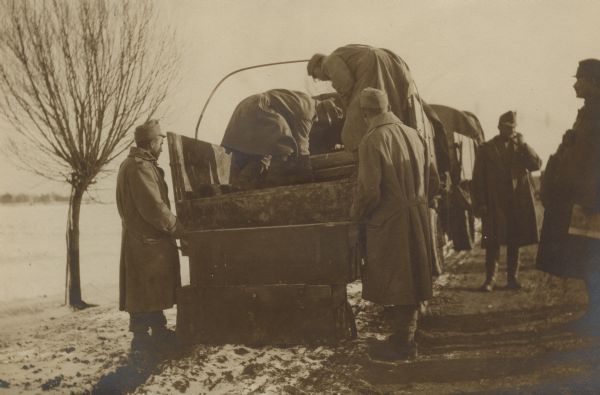 Austrian soldiers are unloading heavy artillery ammunition from the back of a truck in Galicia.
