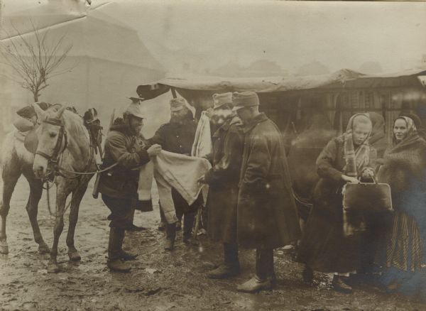 Austrian soldiers, including an Uhlan, are buying woolen clothing for the winter.