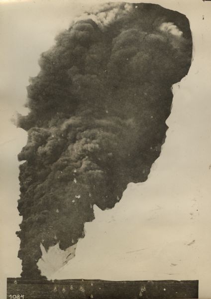 The Turkish light cruiser Midilli, formerly the German ship S.M.S. Breslau, bombarding the Russian Black Sea port of Novo Rossiysk. A Russian freighter is on fire.