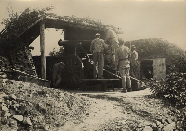 Austrian soldiers are manning an artillery piece in a bunker on the battlefield in South  Tyrol. The German caption states "We salute you again Italy" referencing that this antiquated piece of heavy artillery had been used previously in a battle against Italy.