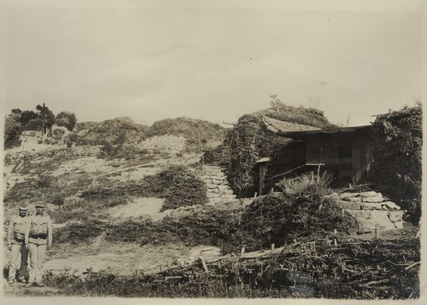 Austrian soldiers post in front of the bunkers on the Italian front in the battle zone around Lavarone in South Tyrol. These are camouflaged artillery positions that cannot be observed by the enemy.