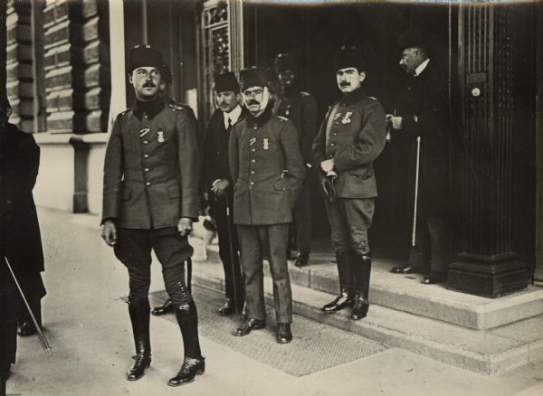 Wounded Turkish officers in Berlin are standing on the sidewalk near the entrance to a building. The officers are convalescing in Berlin sometime after the Ottoman Empire entered the war on the side of Germany in October 1914.