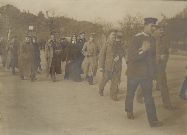 Wounded soldiers, and their nurses, walking across the Kaiser Franz Joseph square in Berlin. 