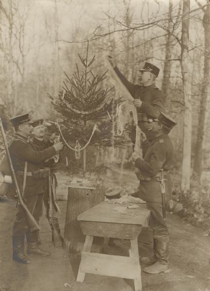 German Landsturm (reservists) trimming a Christmas tree and giving gifts. 