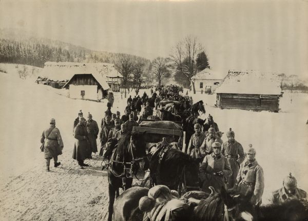 Elevated view of a German artillery column in the Carpathian Mountains. Buildings are in the background.