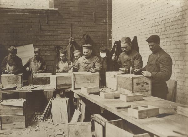 Soldiers packing tins for shipment. 