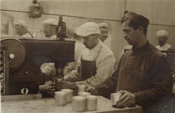 Preparing and sealing tins of meat to be provided to soldiers on the front.