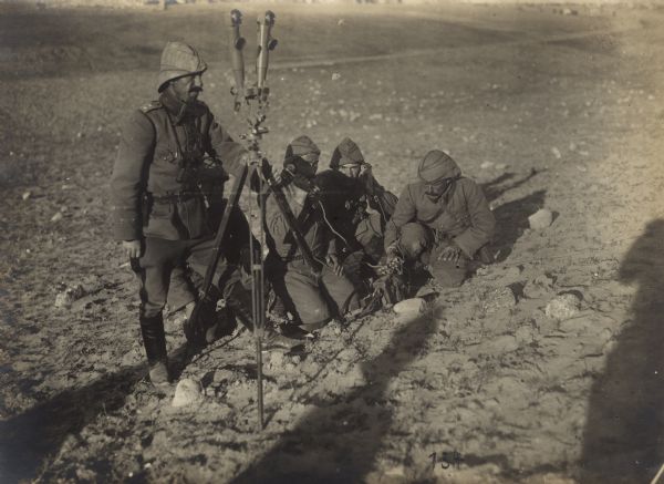 Soldiers with field telephone and periscope binoculars in the desert.