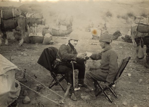 A Turkish Army doctor is bandaging the hand of a soldier who was bitten by a camel.