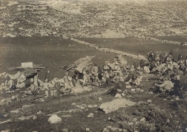 Caravan of Red Crescent soldiers traveling through the desert with supplies.