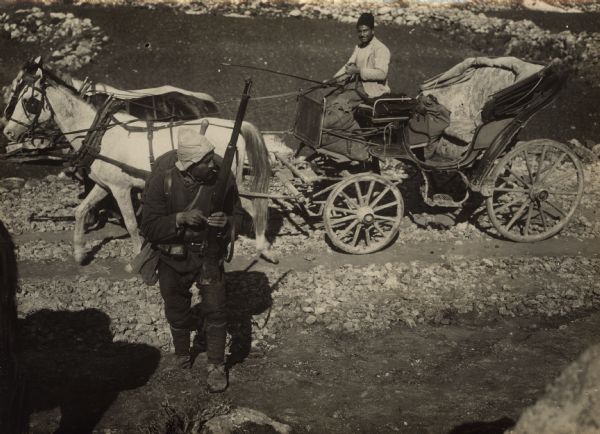 Turkish soldier in front of a carriage.