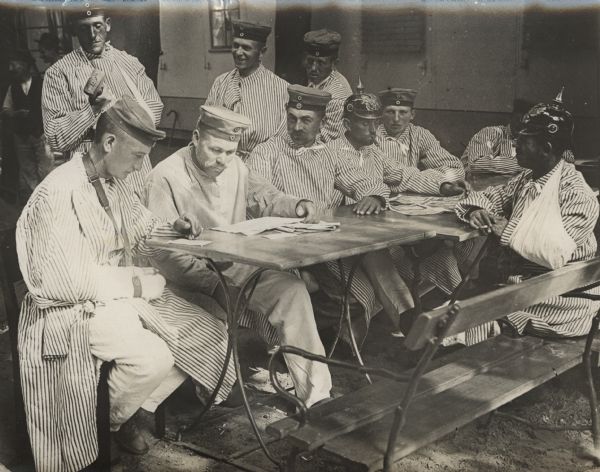 The first wounded soldiers in Berlin. Soldier in left foreground has to write with his left hand since his right hand was wounded.