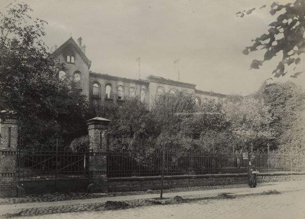 A woman is walking in front of the seminary building in Ortelsburg.