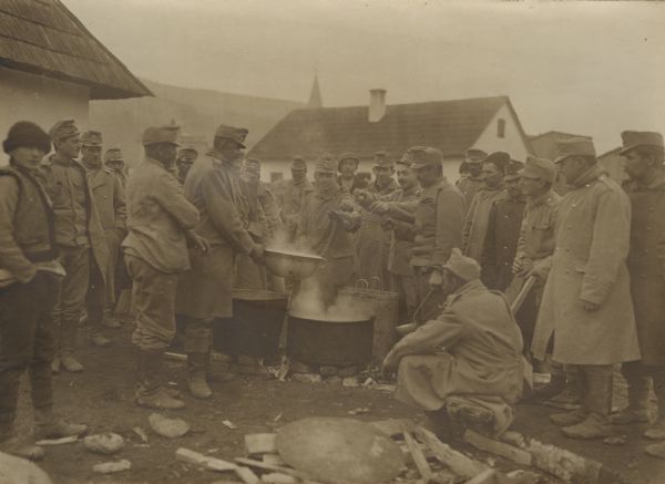 Austrian soldiers and civilians gathered around a fire.