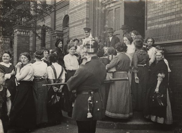 Daily scenes of the crowd gathered in front of the garrison door waiting to receive a free noon day meal from soldier's kitchen.