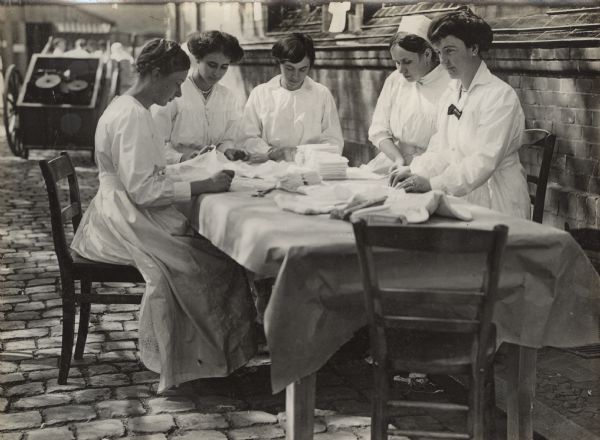 Ladies of higher standing working in the medical depot preparing dressings.
