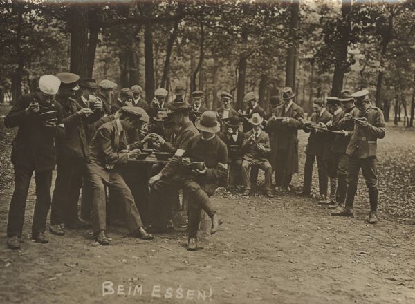 German Army recruits, still in civilian clothing, taking a meal break.