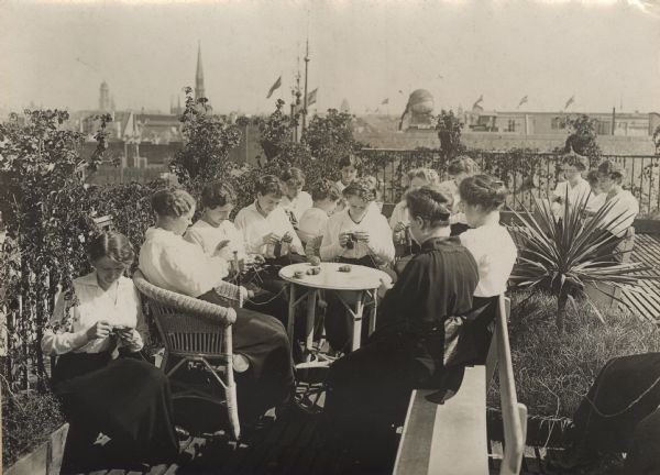 Patriotism on the roof veranda. Employees of a large store in Berlin using their free time to knit socks for our brave fighters.