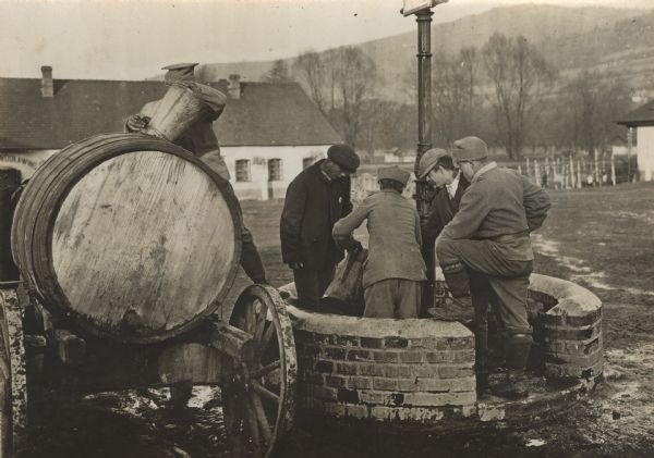 Austrian soldiers filling a water wagon from a well.