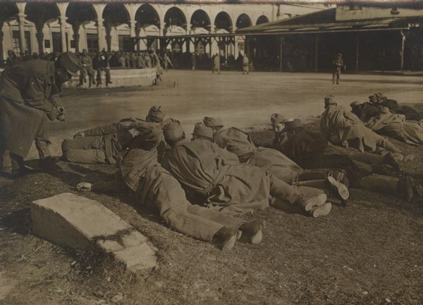 Wounded Austrian soldiers lounge on the ground in the "Wiener Rotunde."