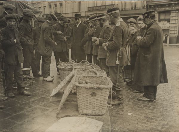 Our naval soldiers buying fruit. German forces occupied Antwerp on October 10th, 1914 after a two week siege.