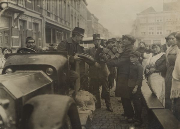 Dutch soldiers distributing bread to refugees in the marketplace of Bergen op Zoom in Holland.
