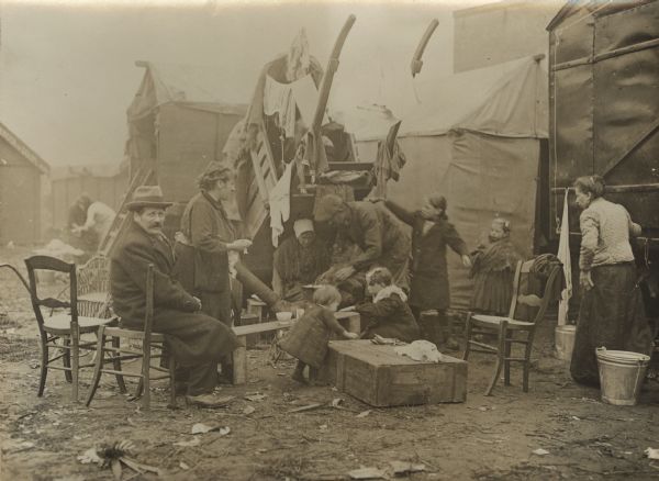 Refugees trying to get warm by the fire in a makeshift tent city.