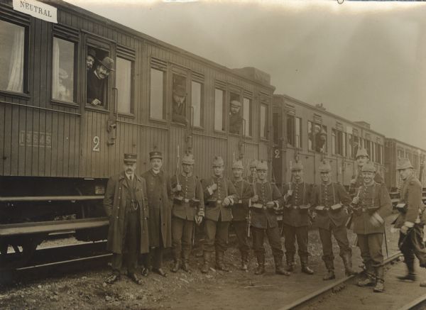 German soldiers and Dutch officials in front of a neutral train transporting refugees back to Belgium.