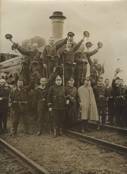 Dutch officials and German soldiers in front of the locomotive pulling the train returning Belgian refugees from Holland.
