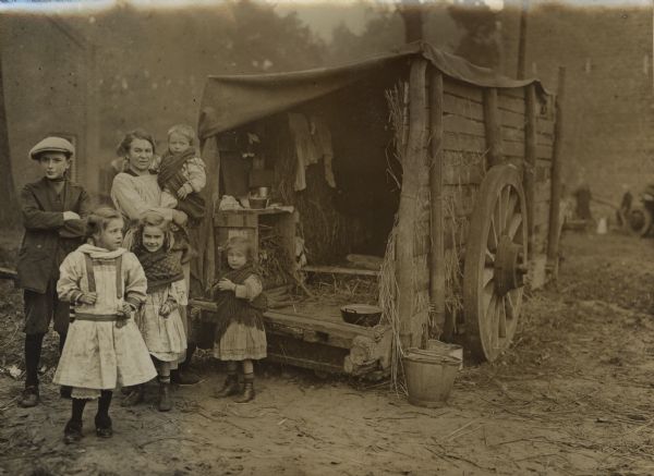 A wagon is serving as an emergency shelter for a refugee family.
