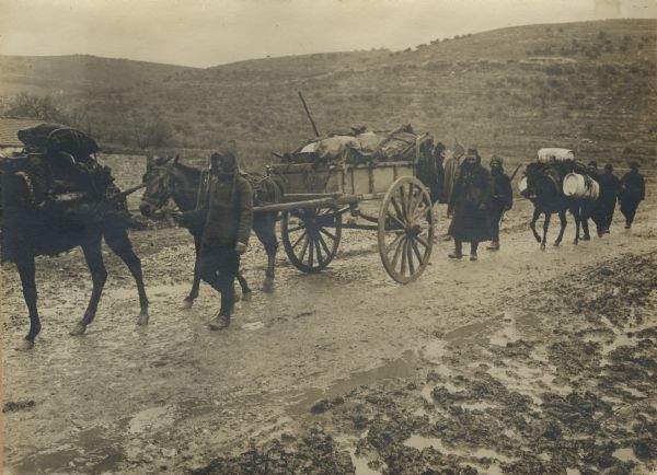 Military transport wagon on a two-wheeled cart in the Taurus Mountains followed by a mule carrying water containers.